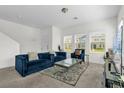 Sunlit living room with comfortable blue sofa, stylish decor, and large windows at 3206 Water Sprite St, Orlando, FL 32808
