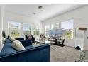 Bright living room with large windows, plush blue seating, and a contemporary glass coffee table at 3206 Water Sprite St, Orlando, FL 32808
