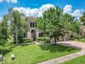 Beautiful home boasts lush green lawn, mature trees, and a paver driveway at 3213 Kentshire Blvd, Ocoee, FL 34761