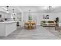 Open-concept dining area with modern light fixture and wood-look floors, seamlessly connected to the living space at 322 Shadow Oak Dr, Casselberry, FL 32707