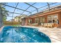 Stunning screened-in pool area with lounge seating, outdoor dining set and well-maintained yard at 356 Via Tuscany Loop, Lake Mary, FL 32746