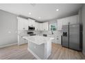 Bright kitchen with stainless steel appliances, quartz countertops, center island and sleek, all-white cabinetry at 3944 Sw 130Th Loop, Ocala, FL 34473