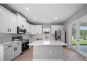 Bright kitchen with stainless steel appliances, quartz countertops, center island and sleek, all-white cabinetry at 3944 Sw 130Th Loop, Ocala, FL 34473