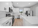 Bright kitchen with stainless steel appliances, quartz countertops and sleek, all-white cabinetry at 3944 Sw 130Th Loop, Ocala, FL 34473