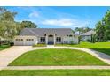 Beautifully landscaped single-story home with three-car garage and circular driveway at 5913 Masters Blvd, Orlando, FL 32819