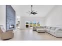 Bright living room with a statement fireplace, vaulted ceiling, and sliding glass doors at 5913 Masters Blvd, Orlando, FL 32819