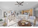 Open-concept living space with modern furnishings, and a seamless transition to the kitchen and dining area at 6411 Chorus Dr, Mascotte, FL 34753