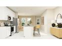 Bright kitchen with white cabinets, stainless steel appliances, a center island and adjacent dining area at 7342 Ivy Tendril Ave, Orlando, FL 32829