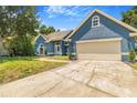 Charming blue home with a well-manicured lawn and inviting curb appeal, featuring a spacious two-car garage at 7838 Rollingridge Ct, Orlando, FL 32835