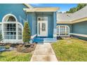 Inviting front porch with a glass door and lovely landscaping, creating a welcoming entrance to the home at 7838 Rollingridge Ct, Orlando, FL 32835