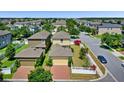Aerial view of a home with a detached garage, white fencing, and red brick driveway at 8057 John Hancock Dr, Winter Garden, FL 34787