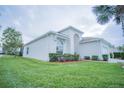 Side view of a white single-Gathering home with well-manicured lawn and minimal landscaping; providing a serene, private atmosphere at 8100 Fan Palm Way, Kissimmee, FL 34747