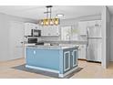 Modern kitchen includes white cabinets, stainless steel appliances, and a stylish island at 9014 Great Sound Dr, Orlando, FL 32827
