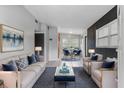 Bright living room with modern furniture, blue accents, and an open floor plan leading to the dining area at 1330 Lakeview Rd, Lake Wales, FL 33853