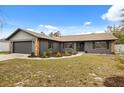 A beautifully renovated single Gathering home featuring a gray exterior, with stone accents and a two-car garage at 15690 Sw 46Th Cir, Ocala, FL 34473