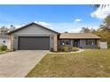 A beautifully renovated single Gathering home featuring a gray exterior, with stone accents and a two-car garage at 15690 Sw 46Th Cir, Ocala, FL 34473