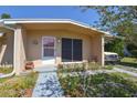 Close-up of the front entrance with a covered porch and minimalist landscaping at 1732 Oasis Ave, Deltona, FL 32725