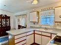 Traditional kitchen with white cabinets, light countertop, and view into adjacent room at 204 Holland St, Lake Wales, FL 33859