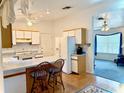 Open concept kitchen with breakfast bar, white cabinets, appliances, and a view into the cozy living room at 204 Holland St, Lake Wales, FL 33859