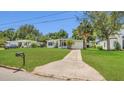 Inviting home featuring a lush green lawn, mature trees, and a convenient driveway for easy access at 2525 Lafayette Ave, Winter Park, FL 32789