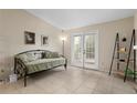 Bright living room featuring a neutral color palette, tile flooring, and a glass sliding door at 2550 N Alafaya Trl # 2304, Orlando, FL 32826