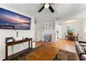 Open-concept living space featuring wood floors, a modern TV, and a view into the dining area at 2710 W County Road 44, Eustis, FL 32726