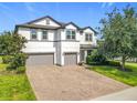 Attractive two-story home with well-maintained landscaping and a spacious brick driveway, offering a welcoming appeal at 3184 Pinenut Dr, Apopka, FL 32712