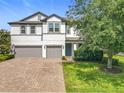 Charming two-story home with lush front yard and brick-paved driveway, providing a warm and inviting entrance at 3184 Pinenut Dr, Apopka, FL 32712