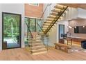 Bright foyer featuring hardwood floors, glass staircase, and modern design elements at 33 Eastwind Ln, Maitland, FL 32751