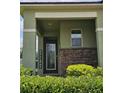 Inviting front porch with brick accents and lush landscaping at 3371 Yellowtop Loop, Clermont, FL 34714