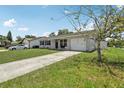 A single-story home with grey siding, a concrete driveway and an attached one car garage at 3816 Tram Ct, Orlando, FL 32810