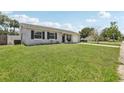 A single-story home with grey siding, dark shutters, a green lawn and an attached garage at 3816 Tram Ct, Orlando, FL 32810
