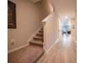 Bright hallway with wood-look tile flooring and carpeted stairs leading to the upper level at 391 Cape Honeysuckle Pl, Sanford, FL 32771