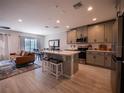 Open-concept kitchen and living area with modern appliances, island seating, and stylish décor at 391 Cape Honeysuckle Pl, Sanford, FL 32771