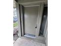 A close-up of a solid front door with a sidelight, set in a neutral-colored exterior at 4596 Pheasant Run Dr # C, Orlando, FL 32808
