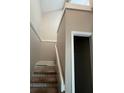 A carpeted stairwell leading upstairs with white railings and neutral-colored walls at 4596 Pheasant Run Dr # C, Orlando, FL 32808