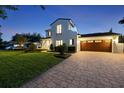 Elegant home with a paver driveway, lush lawn, and a side-entry garage at twilight at 521 S Phelps Ave, Winter Park, FL 32789