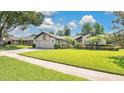 Well-manicured lawn, mature landscaping, and a charming front facade at 623 Tuskawilla Point Ln, Winter Springs, FL 32708
