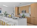 Stylish kitchen showcasing a center island, modern light fixtures, and a breakfast bar with sleek bar stools at 6419 Chorus Dr, Mascotte, FL 34753