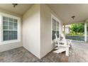 Cozy porch with brick flooring, windows, and white chairs, perfect for relaxation and enjoying the outdoors at 7003 Cupseed Ln, Harmony, FL 34773