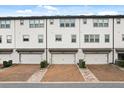 Rear exterior view with multiple garage doors with brick-lined driveways in a townhouse complex at 7724 Sweet Star Ave, Orlando, FL 32836