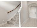 Carpeted staircase with wooden handrail and white trim, leading upstairs from the tiled entryway at 7724 Sweet Star Ave, Orlando, FL 32836