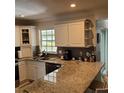 Spacious kitchen featuring granite countertops, white cabinets, and stainless steel sink at 8539 Clematis Ln, Orlando, FL 32819