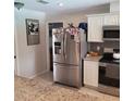 The kitchen featuring a stainless steel refrigerator and granite countertop, a modern and functional space at 8539 Clematis Ln, Orlando, FL 32819