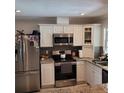 Modern kitchen with stainless steel appliances and white cabinetry providing ample storage space at 8539 Clematis Ln, Orlando, FL 32819