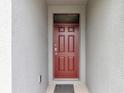 Close-up of a classic red front door with detailed panels and a secure lock at 868 Brooklet Dr, Davenport, FL 33837