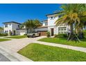 This inviting two-story home features a paved driveway, lush lawn, and meticulous landscaping at 10829 Royal Cypress Way, Orlando, FL 32836