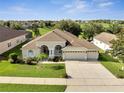 Beautiful house with a three-car garage, lush green lawn, and mature landscaping in a desirable neighborhood at 10955 Lemay Dr, Clermont, FL 34711