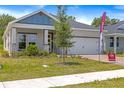 Inviting one-story home boasting a brick-paved driveway, attached two-car garage and manicured lawn at 1257 Champions Dr, Daytona Beach, FL 32124