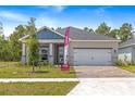 Attractive single-story home with a two-car garage, brick driveway, and well-maintained landscaping at 1257 Champions Dr, Daytona Beach, FL 32124